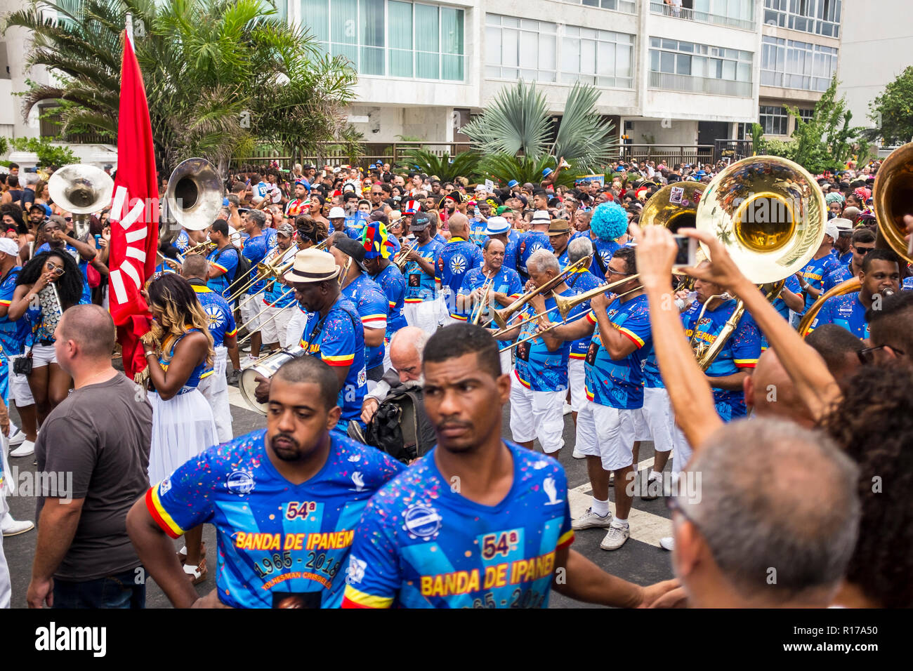 RIO DE JANEIRO - circa Febbraio, 2018: una banda di ottoni nel carnevale camicie noto come abadás conduce la Banda de Ipanema street party lungo il fronte spiaggia Foto Stock