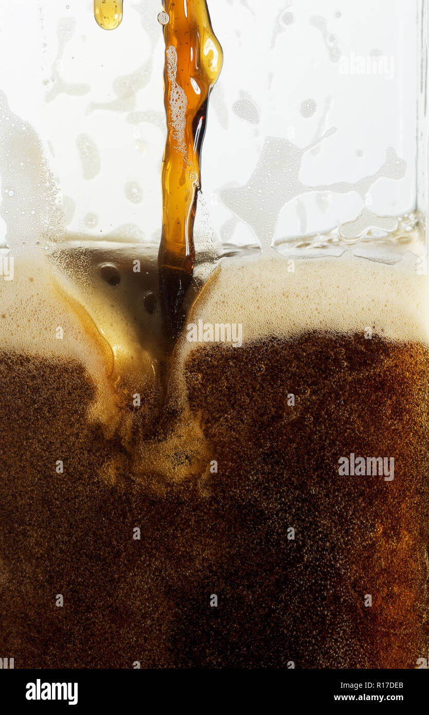 Progetto di Guinness/birra scura versando in un bicchiere, close up dettaglio Foto Stock