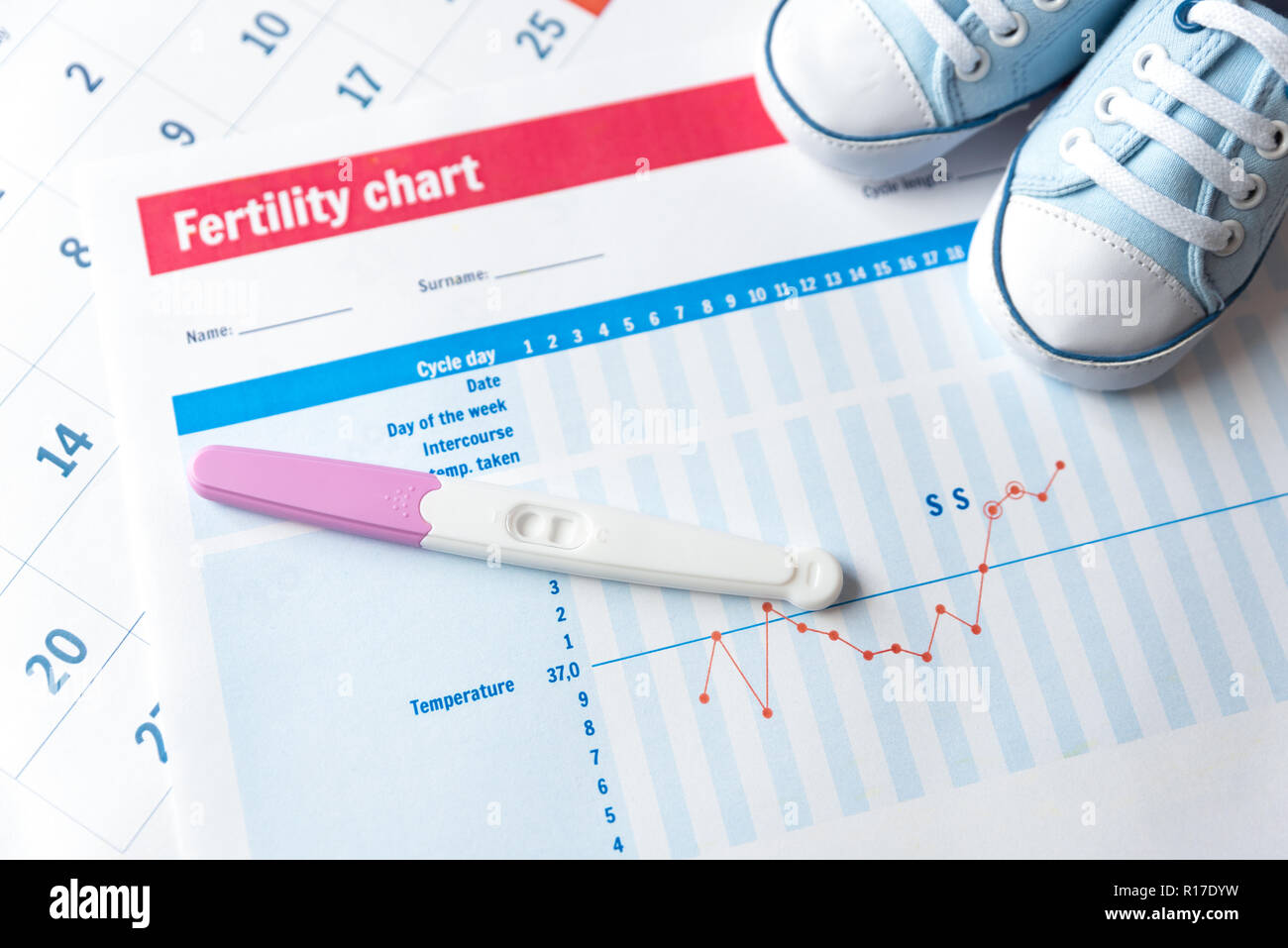 Test di gravidanza e scarpe per bambini sulla fertilità grafico. Aspettiamo un concetto di bambino. Foto Stock