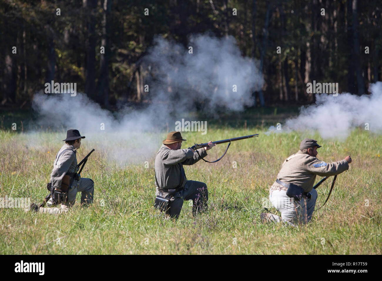 Famiglia MCCONNELLS, SC (USA) - 3 Novembre 2018: Reenactors in divise confederato fire un fucile volley durante una guerra civile la rievocazione di battaglia. Foto Stock