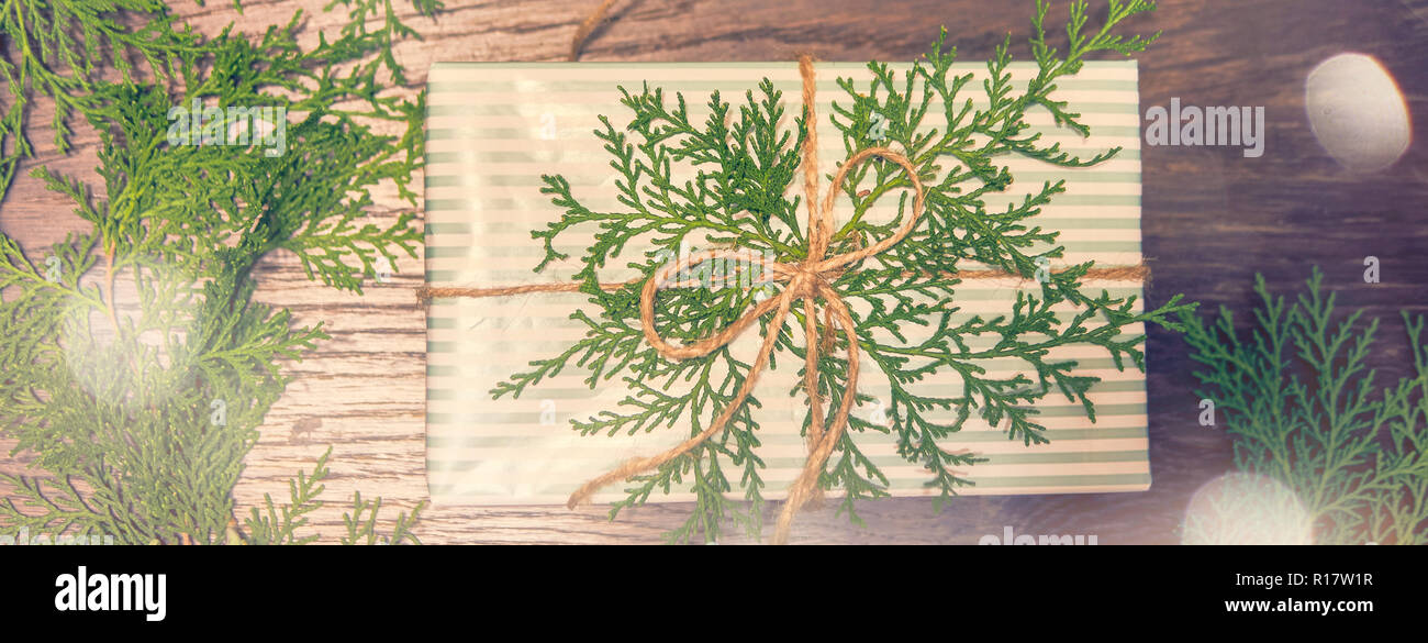 Telaio di natale. Regali di natale, pigne, gypsophila fiori, thuja rami sul bianco sullo sfondo di legno. Appartamento laico, vista dall'alto, spazio di copia Foto Stock