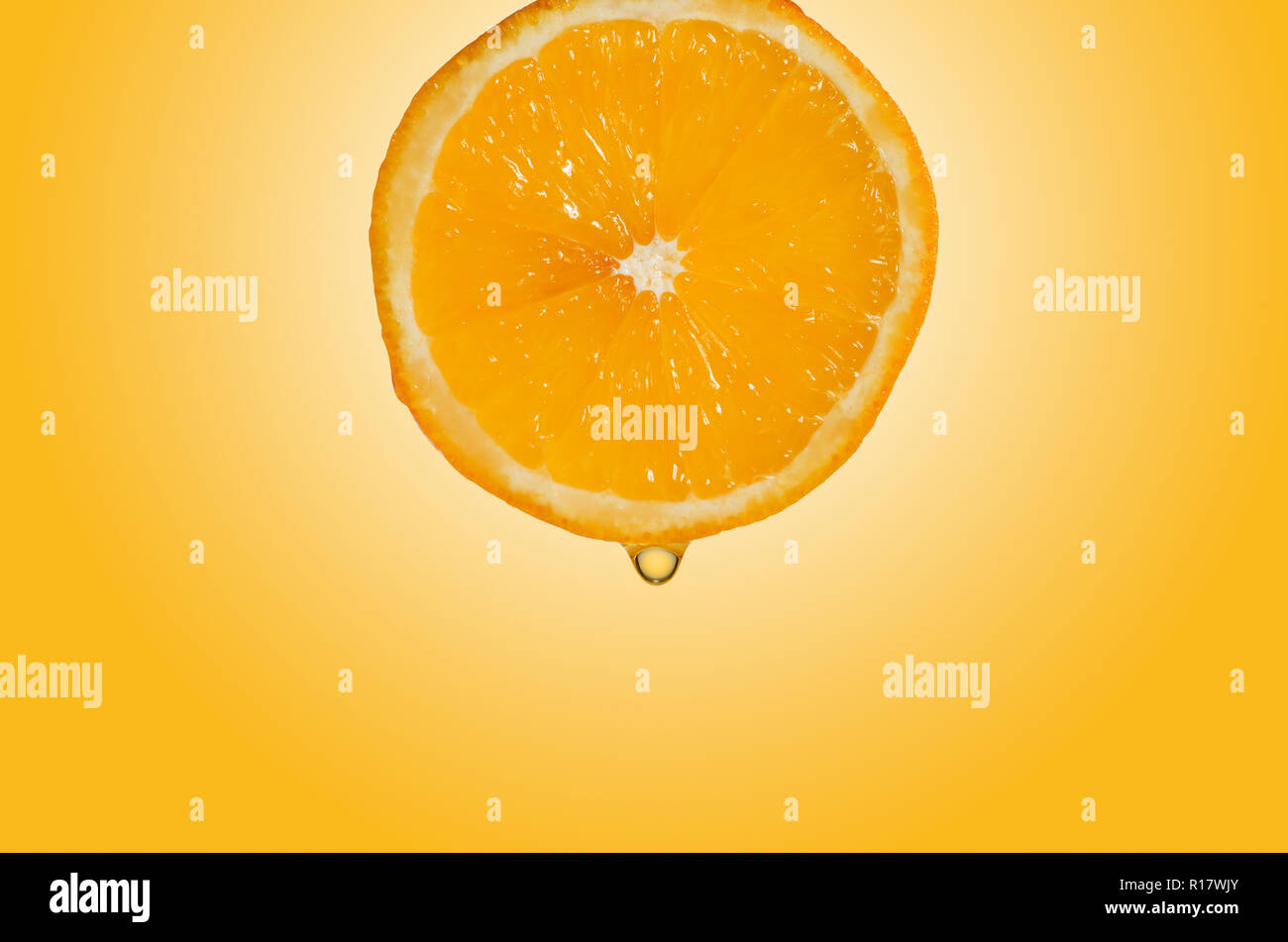 Vista ravvicinata della fetta d'arancia con goccia di succo, sfondo giallo Foto Stock