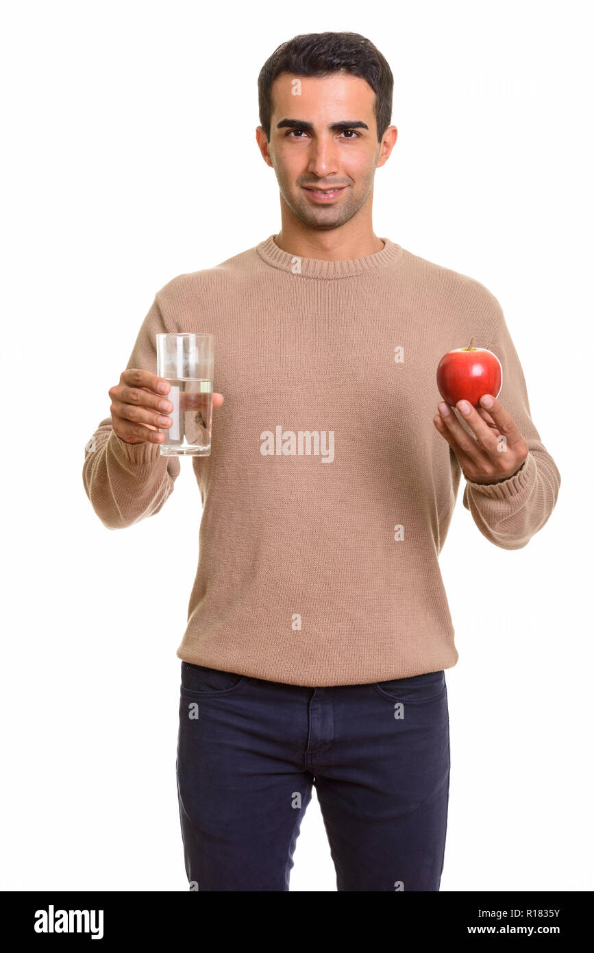 Ritratto di giovane uomo bello tenendo un bicchiere di acqua e Apple Foto Stock