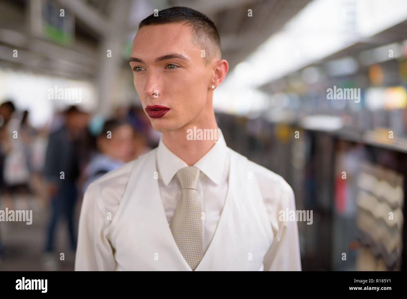 Giovani androgino omosessuale imprenditore LGTB indossando il rossetto Foto Stock