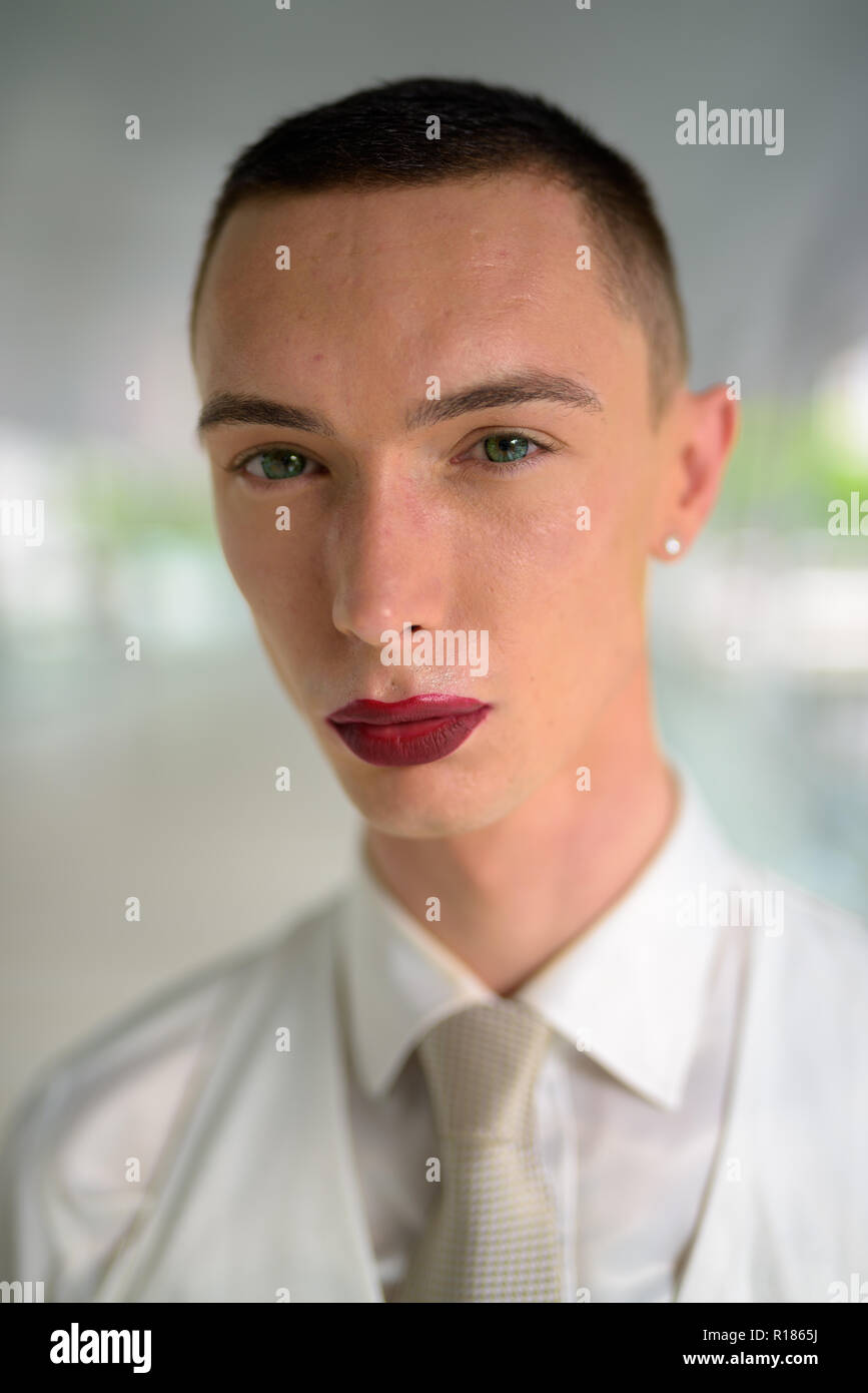 Giovani androgino omosessuale imprenditore LGTB indossando il rossetto Foto Stock