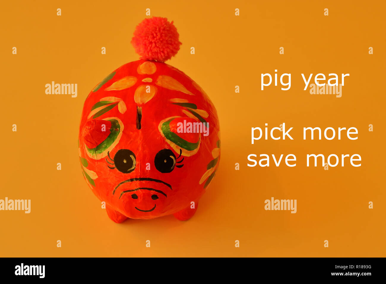Primo piano volto di una donna sorridente salvadanaio costituito da carta oro su sfondo colorato con parole lette anno di maiale, scegliere più, risparmiare di più e concetto di risparmio Foto Stock