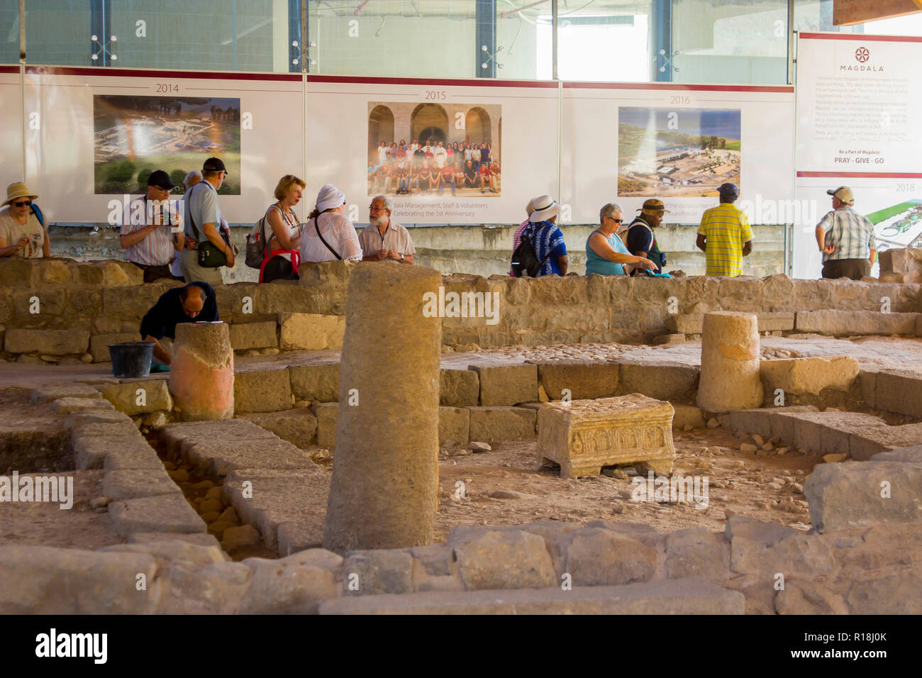 4 maggio 2018 pellegrini ispezionare i lavori di restauro su un secolo sinagoga presso il borgo antico di Magdala in Galilea Israele. Un commerciante continua Foto Stock