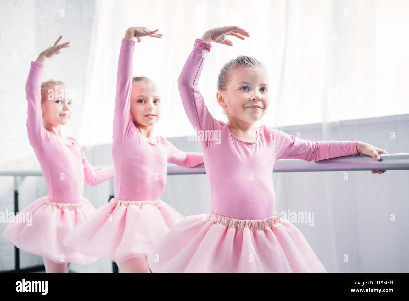 Adorabili bambini sorridenti in rosa tutu gonne dancing in studio di balletto Foto Stock