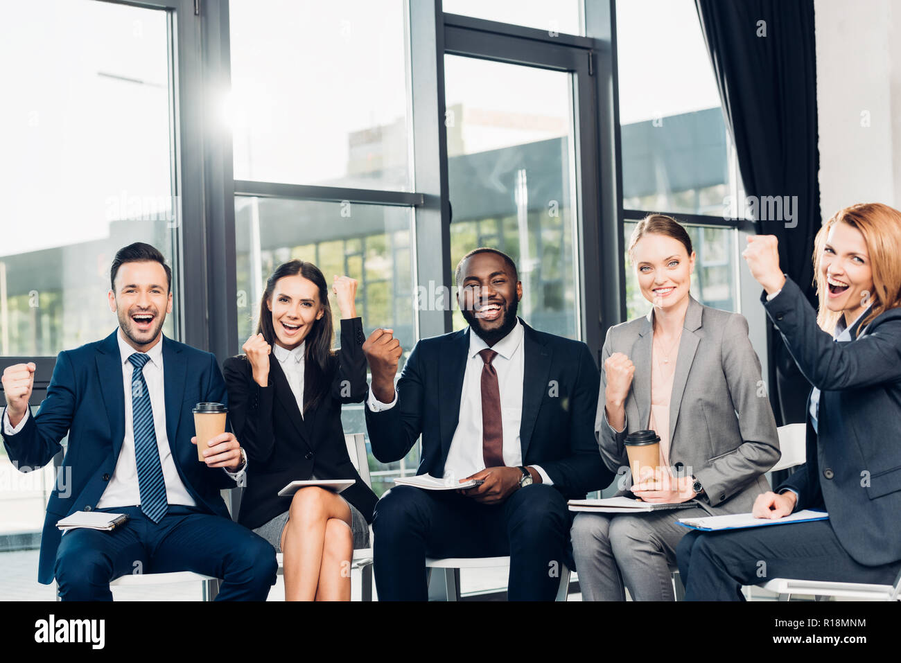 Successo di imprenditori e multirazziale seduti su sedie in sala conferenze Foto Stock