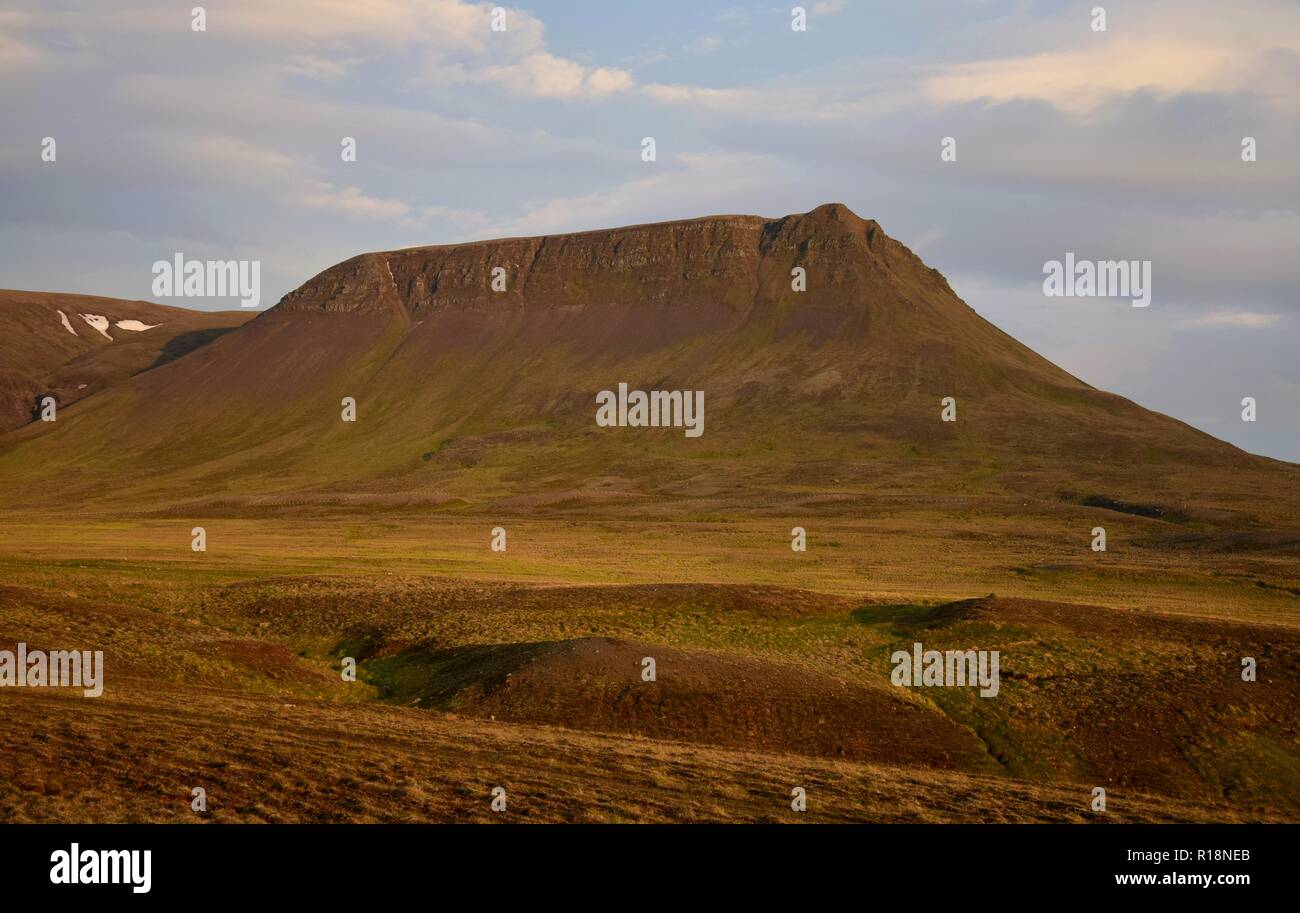 Una notte di mezza estate in Islanda. Una montagna è incandescente nel sole di mezzanotte. Il Vatnsdalsfjall vicino a Blönduos. Una luce blu del cielo. Foto Stock