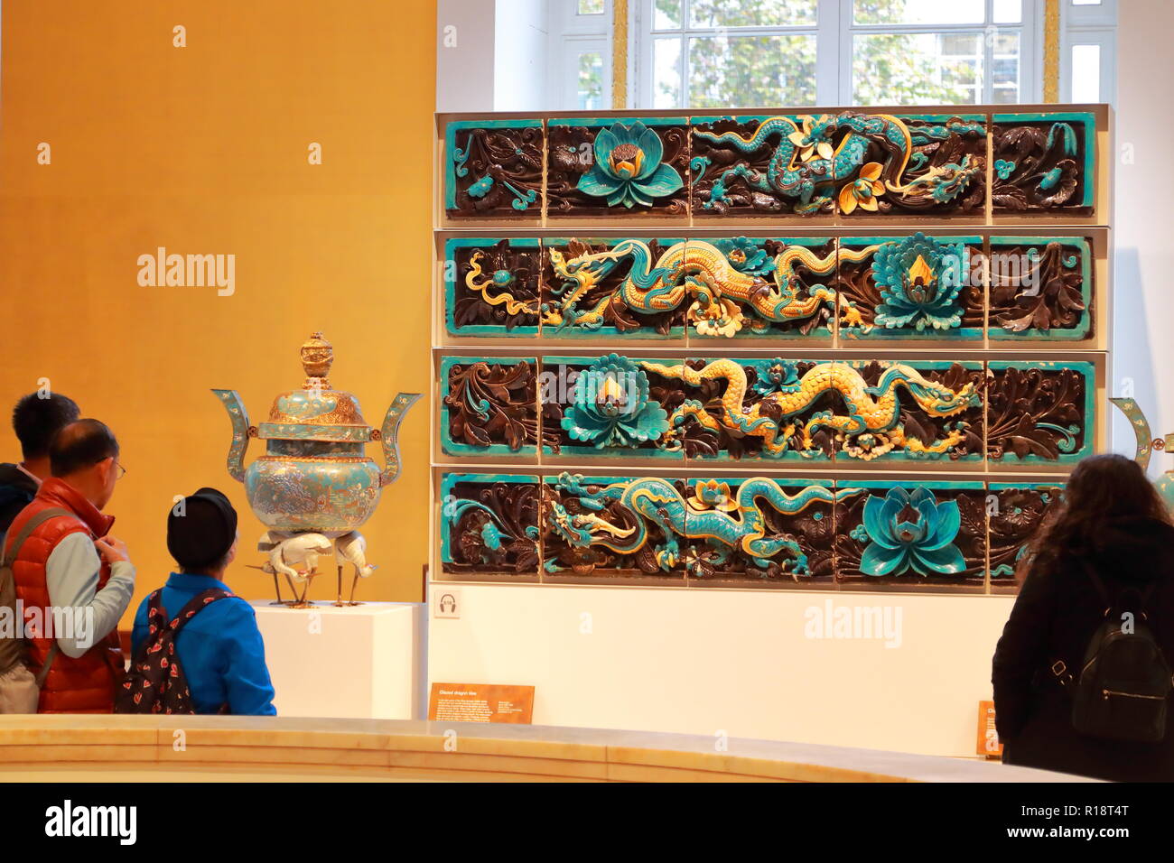 Ai visitatori di ammirare cinese drago smaltate piastrelle presso il British Museum di Londra, Regno Unito Foto Stock
