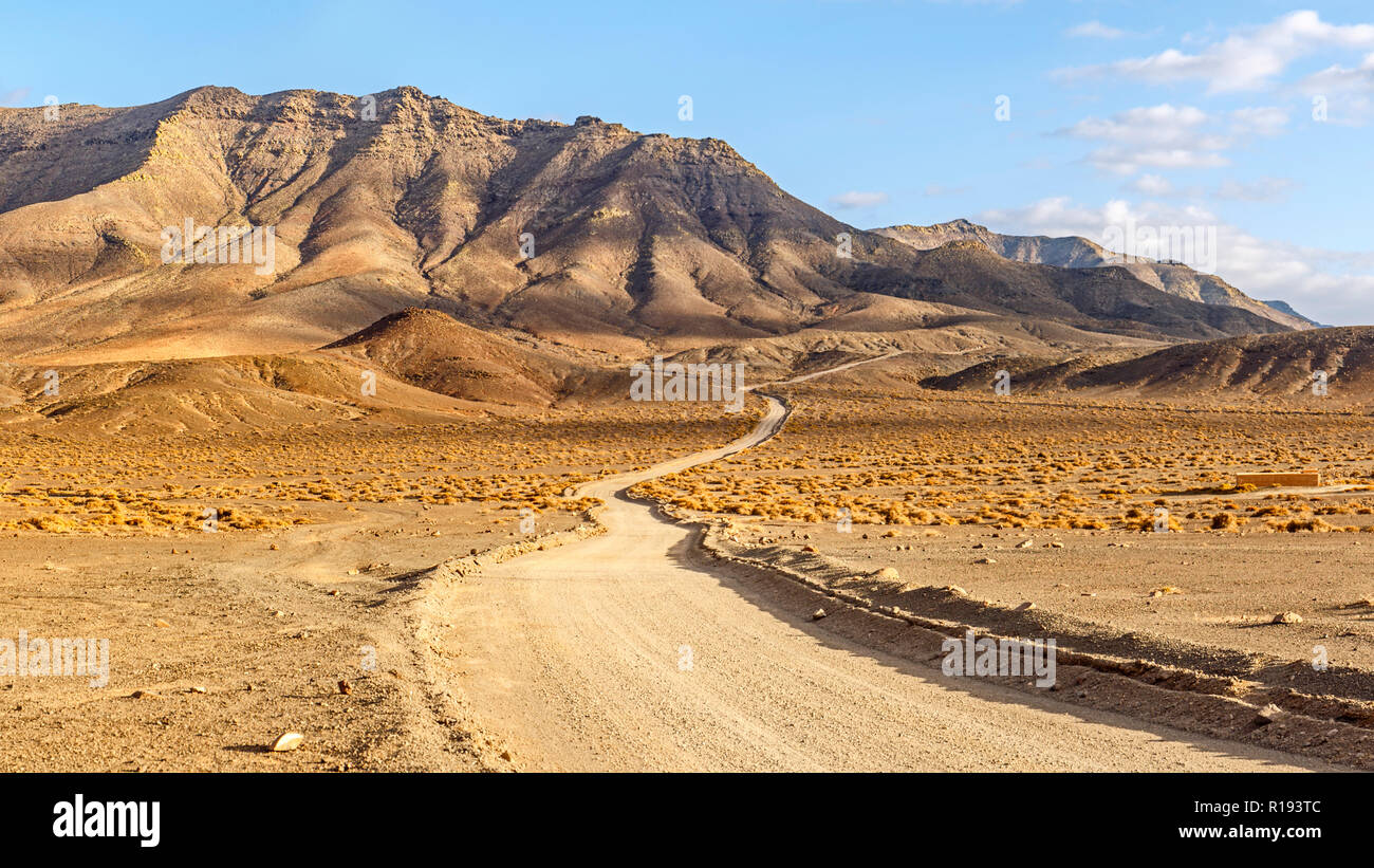 Avvolgimento sporco rurale strada tra paesaggio vulcanico a Fuerteventura a Ora d'Oro Foto Stock
