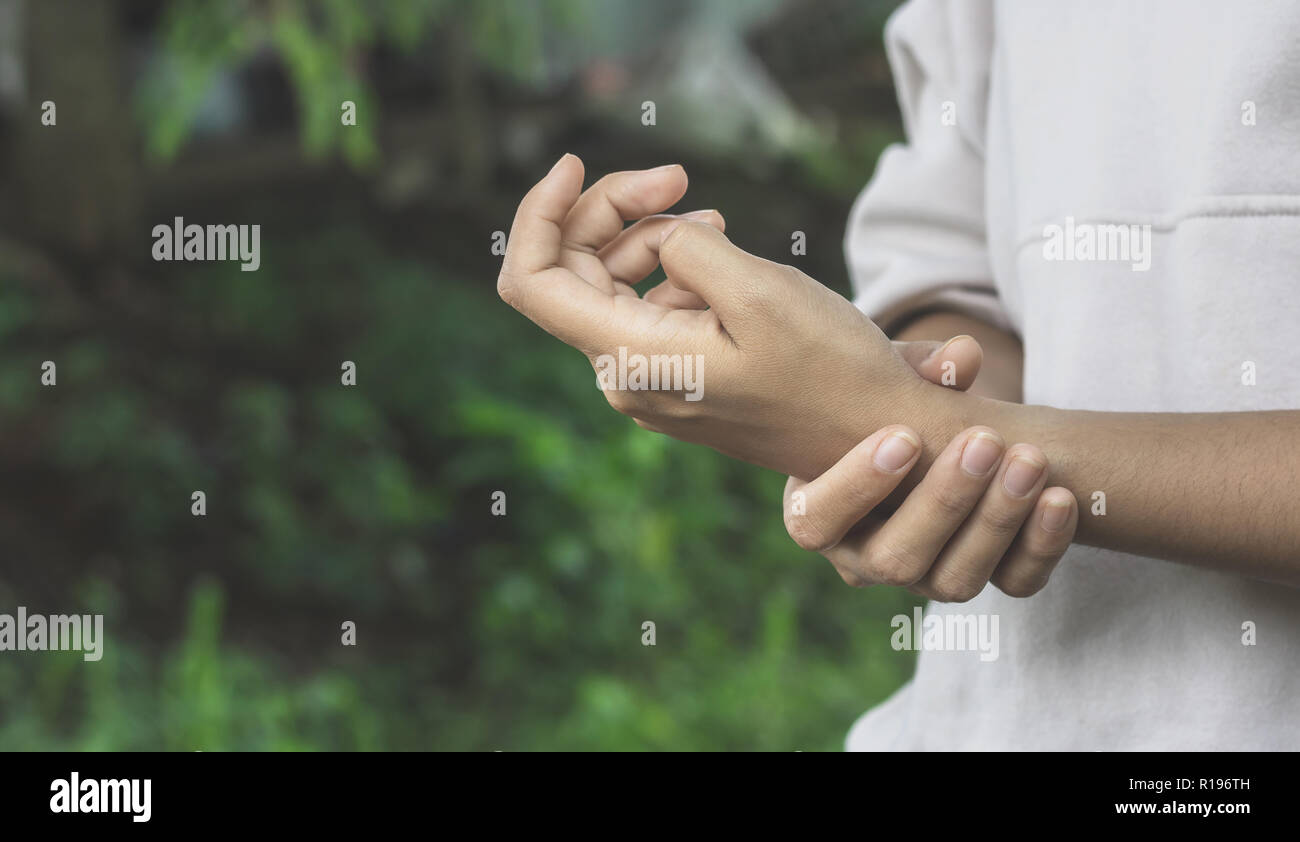 Close up donne asiatiche dolorose mano nel giardino.Concetto Help care Foto Stock