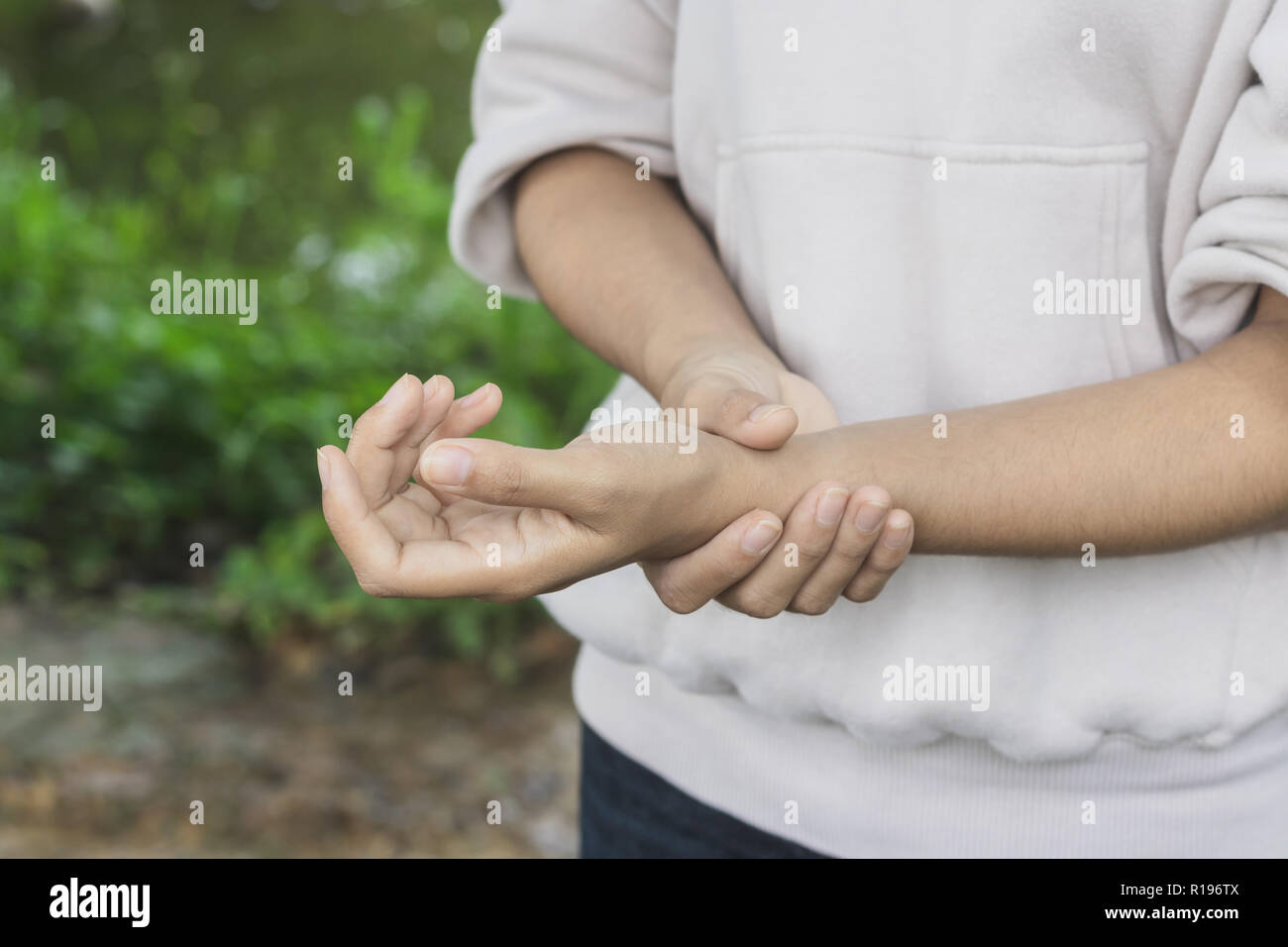 Close up donne asiatiche dolorose mano nel giardino.Concetto Help care Foto Stock