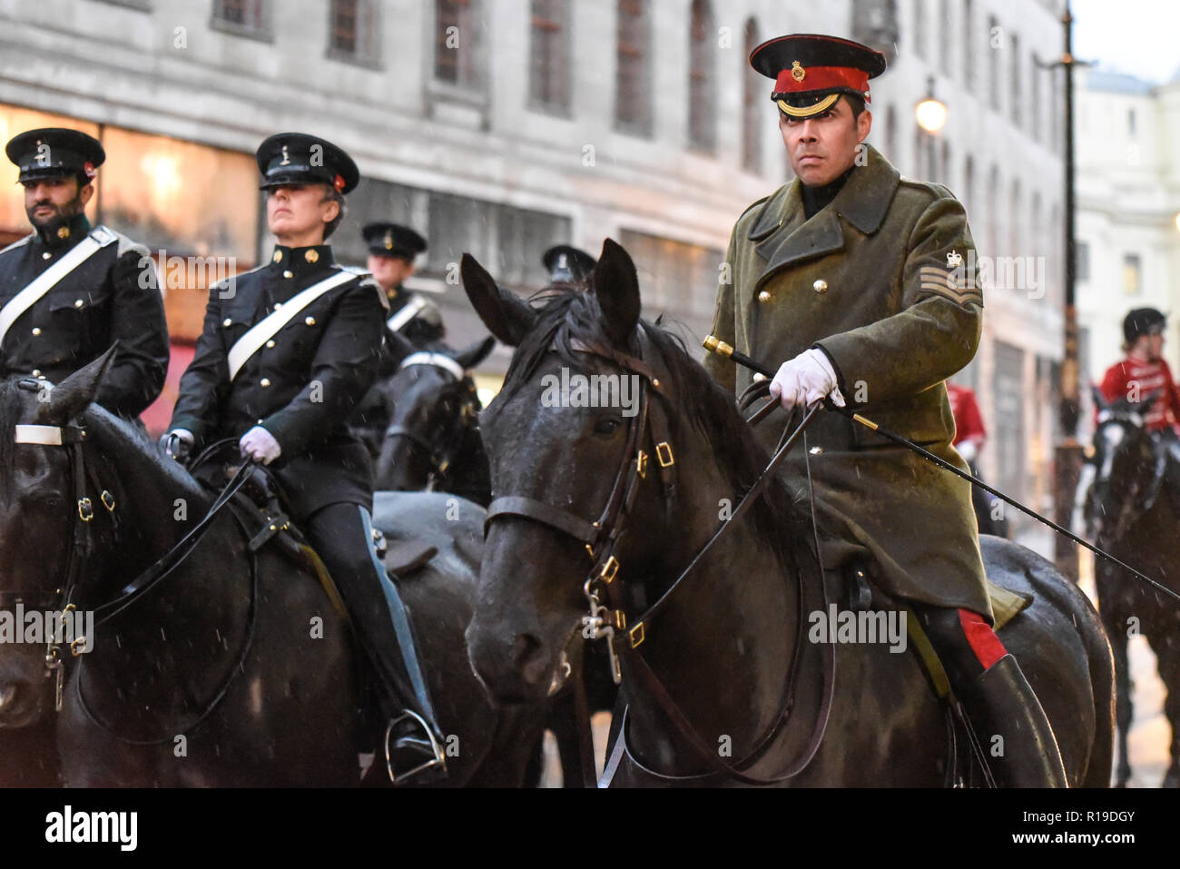 Montate i piloti dell'Esercito britannico Royal Yeomanry ottenere catturati in heavy rain dopo il signore sindaco di mostrare Parade mentre ritornando alla caserma. Rivestimento umido Foto Stock