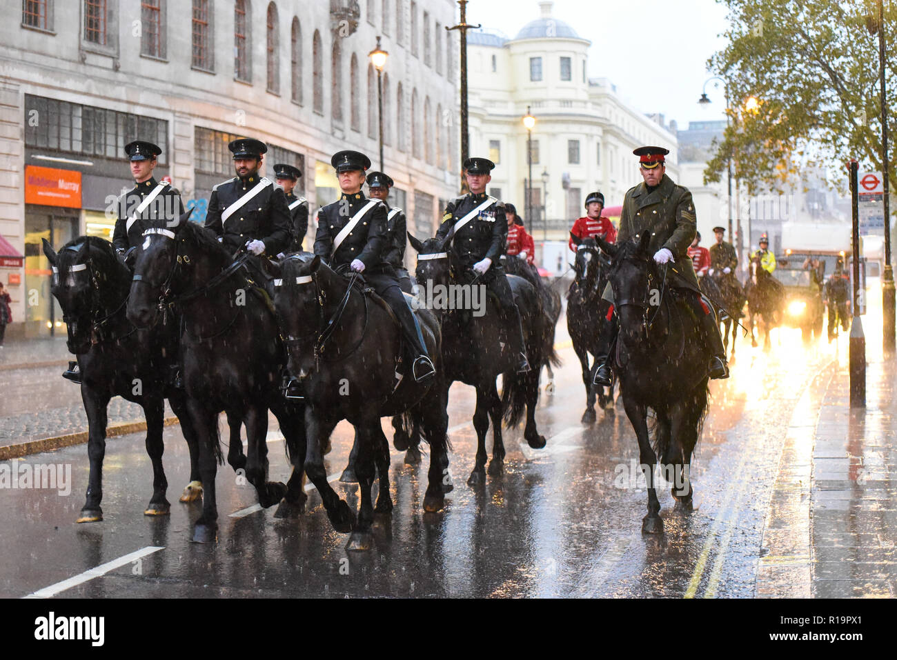 I piloti dell'Esercito britannico Royal Yeomanry ottenere catturati in heavy rain dopo il signore sindaco di mostrare Parade mentre ritornando alla caserma. Le truppe montate Foto Stock