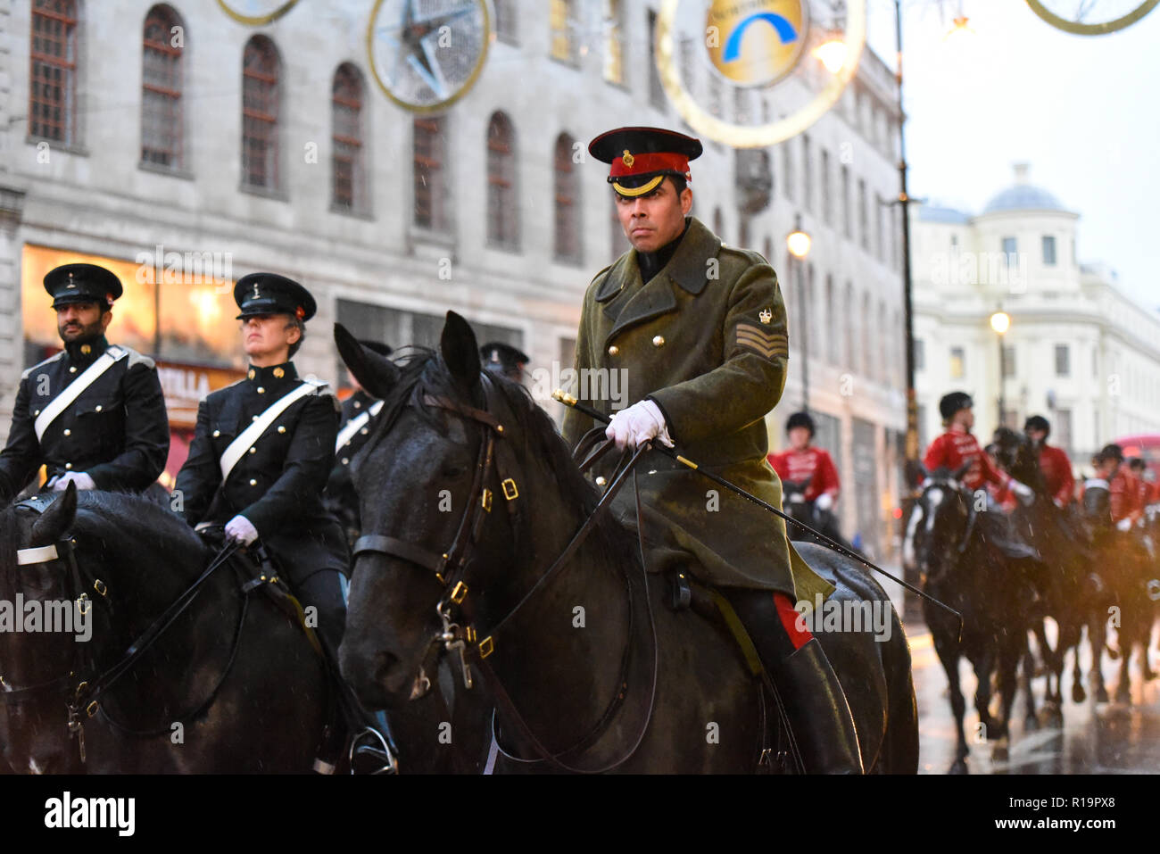 I piloti dell'Esercito britannico Royal Yeomanry ottenere catturati in heavy rain dopo il signore sindaco di mostrare Parade mentre ritornando alla caserma. Le truppe montate Foto Stock