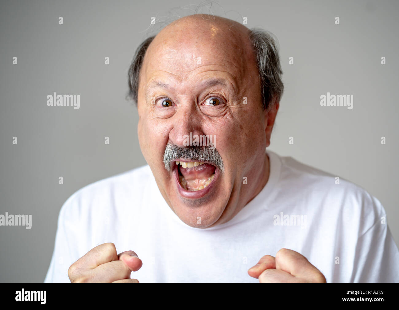 Vecchio uomo adulto gioisce nel conseguire il suo obiettivo, vincere la lotteria o avendo grande successo con sorpresa e faccia felice in espressione facciale e Huma Foto Stock