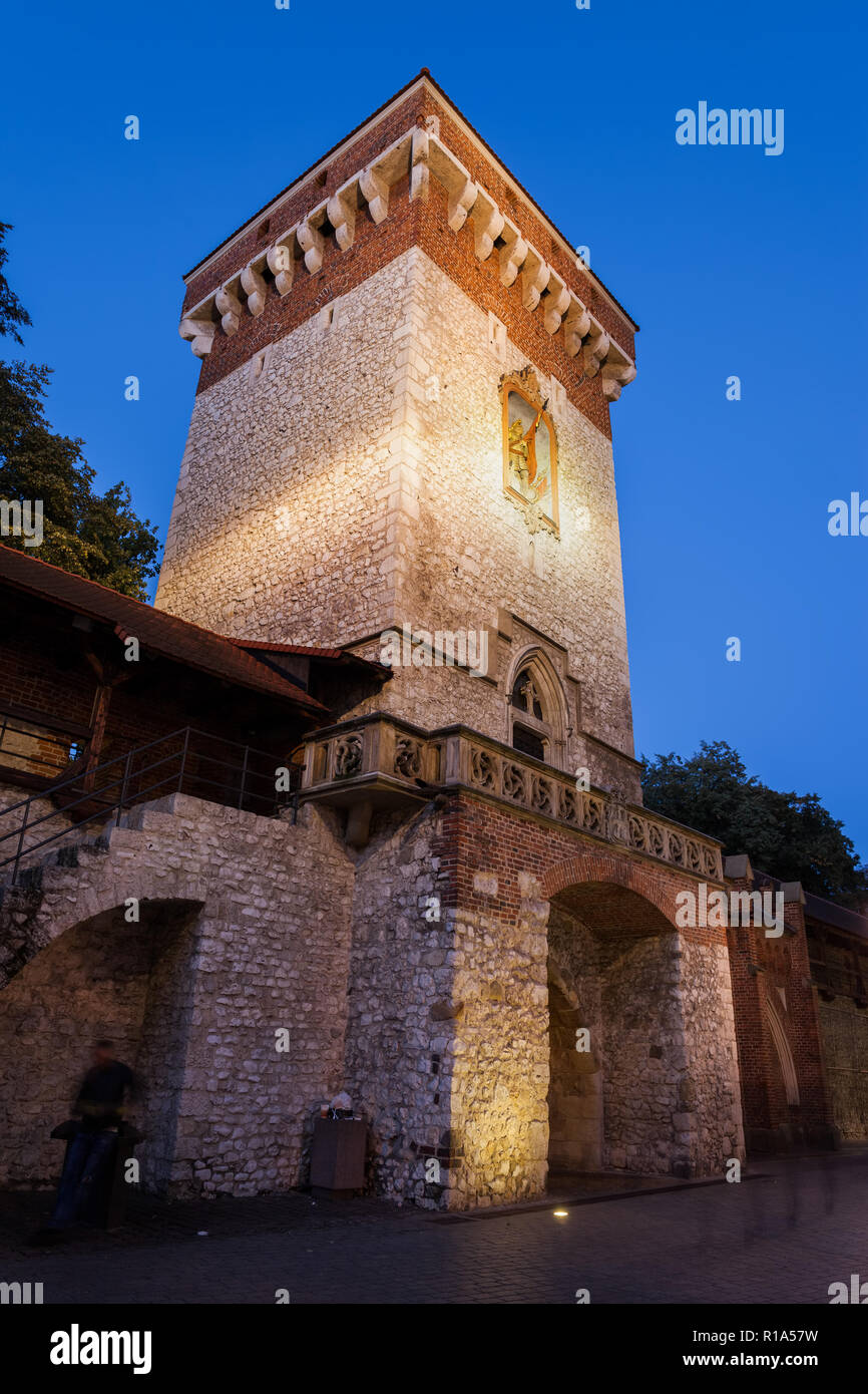 San Floriano porta (Brama Florianska) illuminata di notte nella città vecchia di Cracovia in Polonia. Architettura gotica di punto di riferimento della città risalente al XIV s. Foto Stock