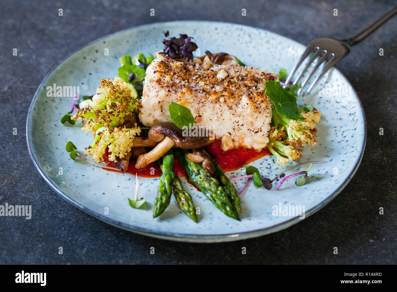 Halibut con crosta di nocciole arrosto con salsa ai peperoni rossi, asparagi, cavolfiori e funghi shiitake Foto Stock