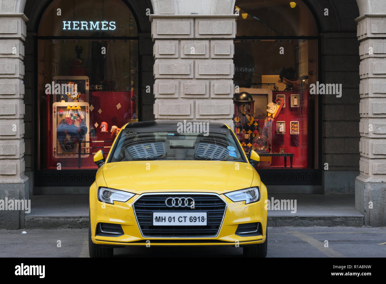 Un costoso Audi auto parcheggiate in Horniman Circle, Mumbai, a fronte di un quartiere alla moda di hermes outlet situati in un British-era l edificio coloniale. Foto Stock