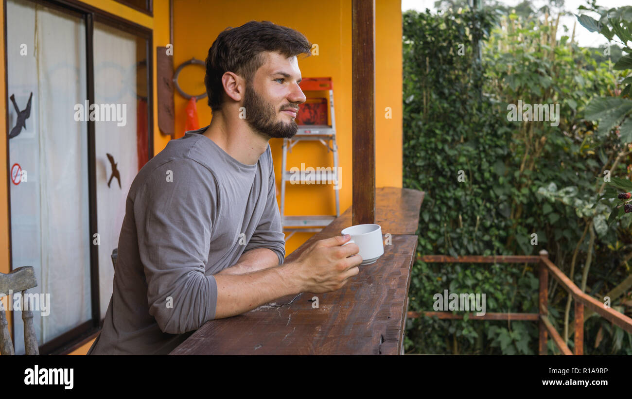 Uomo europeo godendo di tazza di caffè in un luogo tropicale Foto Stock