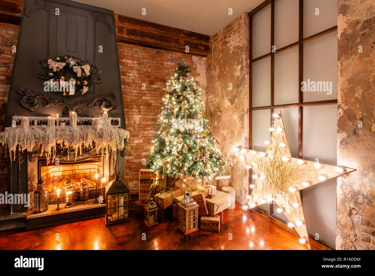 Inverno Home decor. Natale in soppalco interno contro un muro di mattoni.  doni sotto l'albero. lampada a stella con lampadine. ghirlande di luci Foto  stock - Alamy