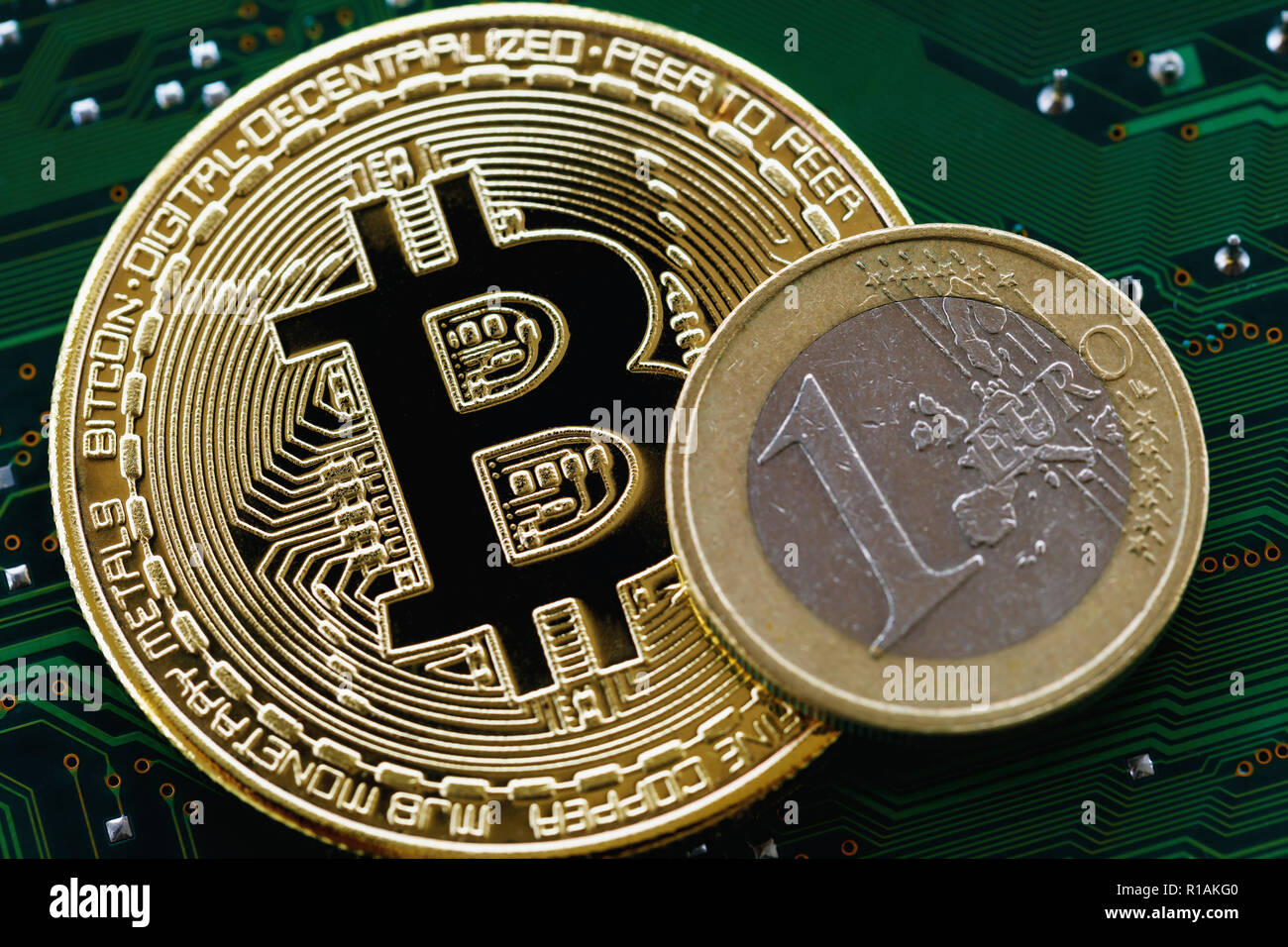Bitcoin e un euro su un chip di computer close-up Foto Stock