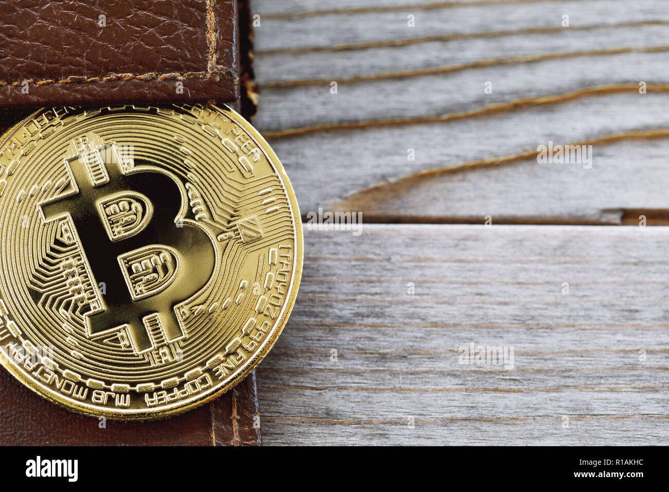 Bitcoin in un portafoglio su una tavola di legno con spazio di copia Foto Stock