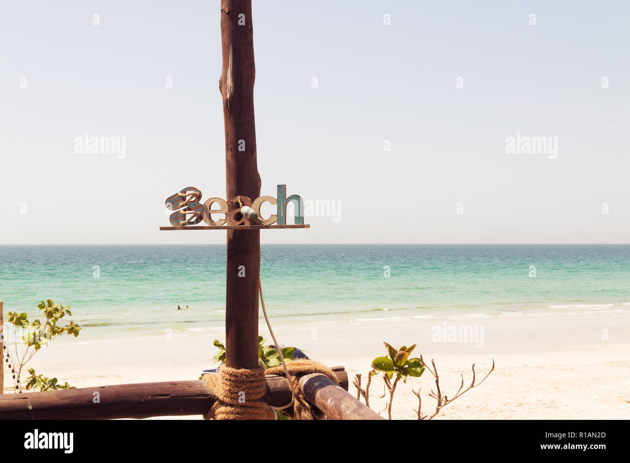 Spiaggia di legno segno estate spiaggia iscrizione, riposo, sabbia, mare. Targa di legno con la scritta spiaggia su una piastra di sfondo del mare. Vocazione decorazioni. Foto Stock