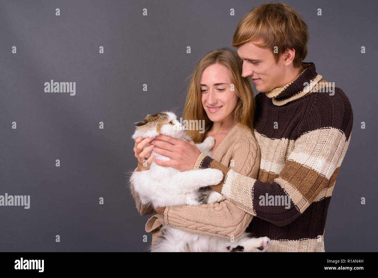 Ritratto di giovane coppia insieme azienda gatto persiano Foto Stock