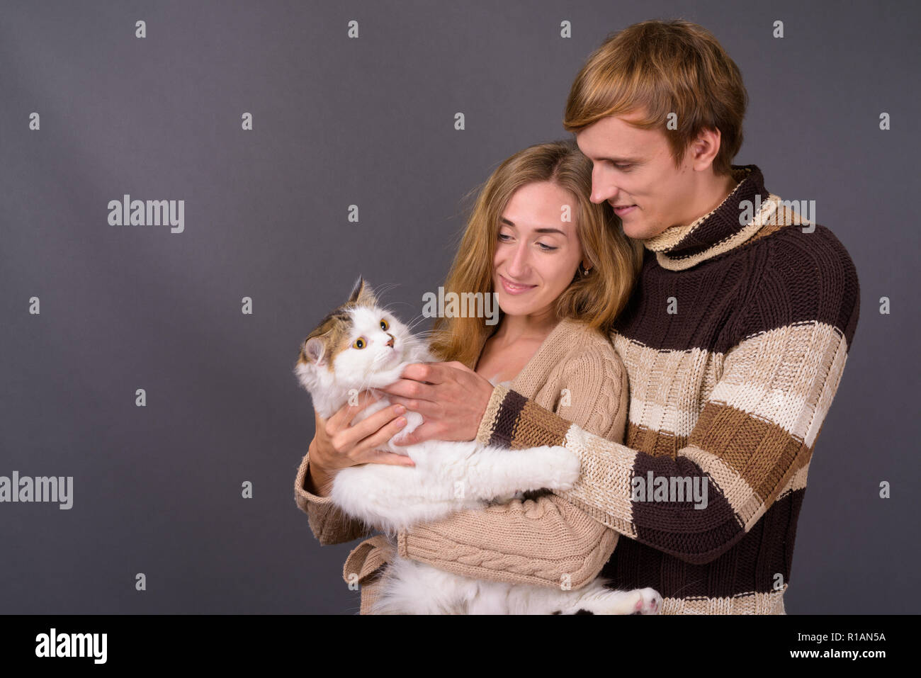 Ritratto di giovane coppia insieme azienda gatto persiano Foto Stock