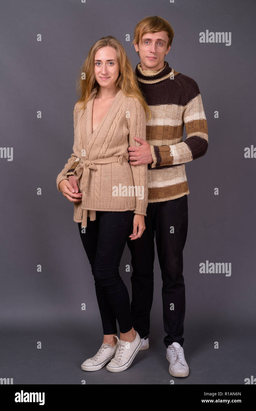 Studio shot di coppia giovane insieme contro lo sfondo grigio Foto Stock