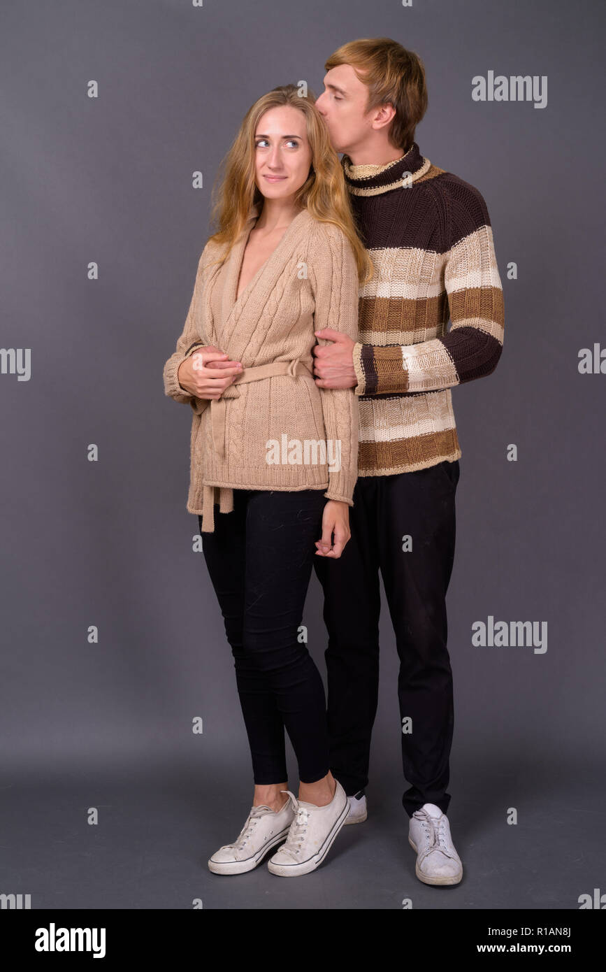 Studio shot di coppia giovane insieme contro lo sfondo grigio Foto Stock