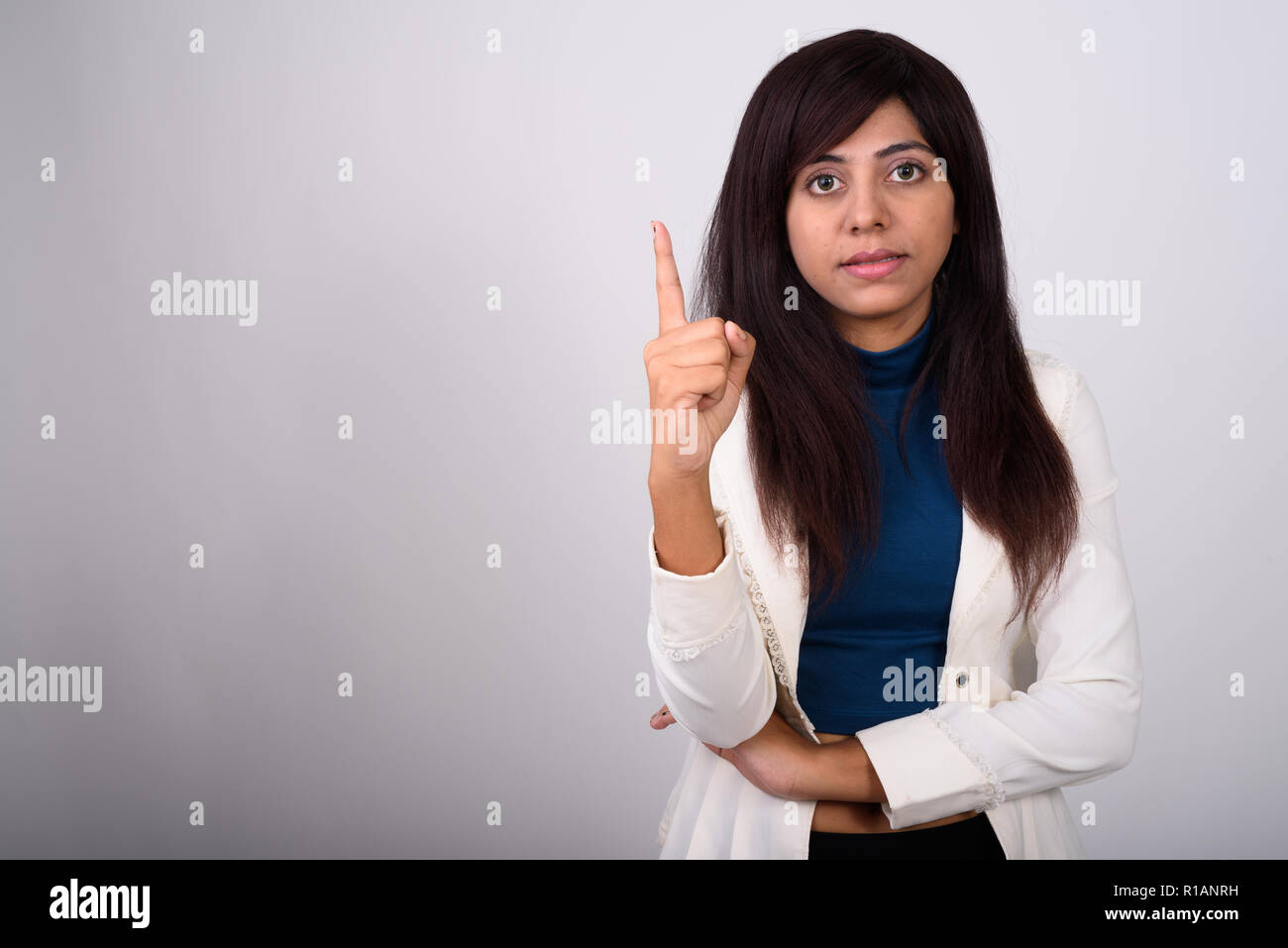 Studio shot di giovane imprenditrice persiano puntare il dito fino ag Foto Stock