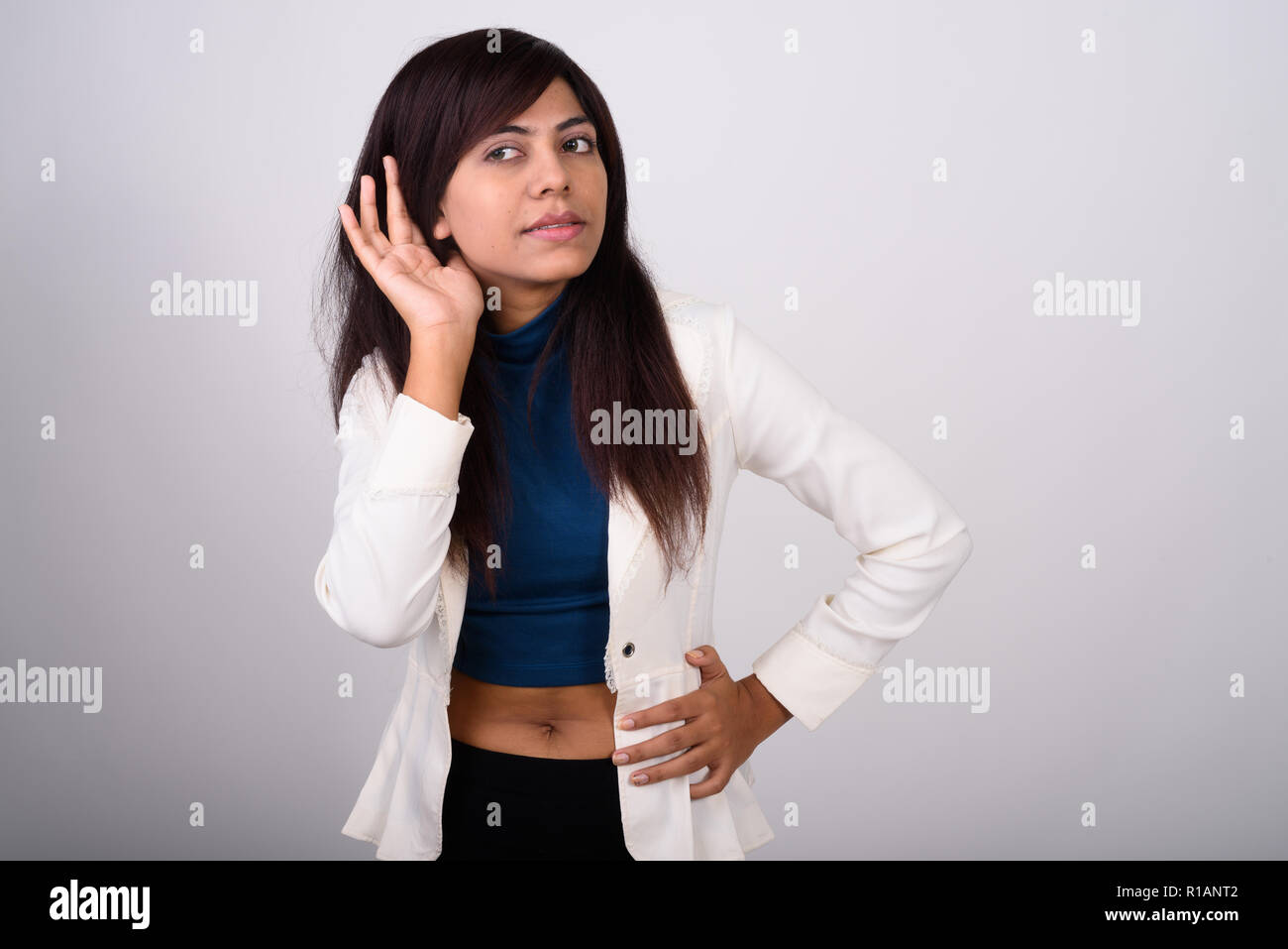 Studio shot di giovane imprenditrice persiano pensando mentre ascolta Foto Stock
