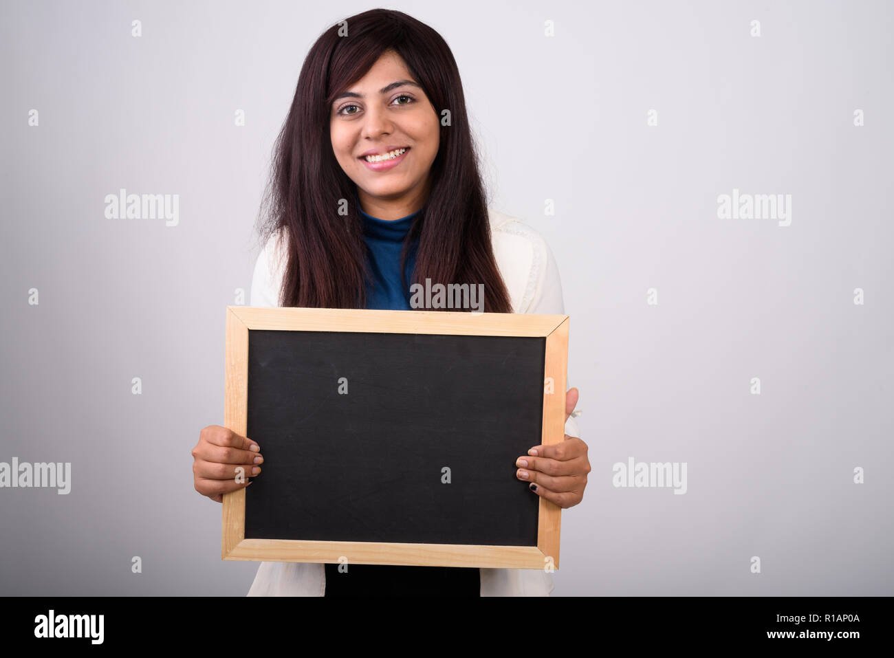 Studio shot di giovani felici imprenditrice persiano sorridere mentre h Foto Stock