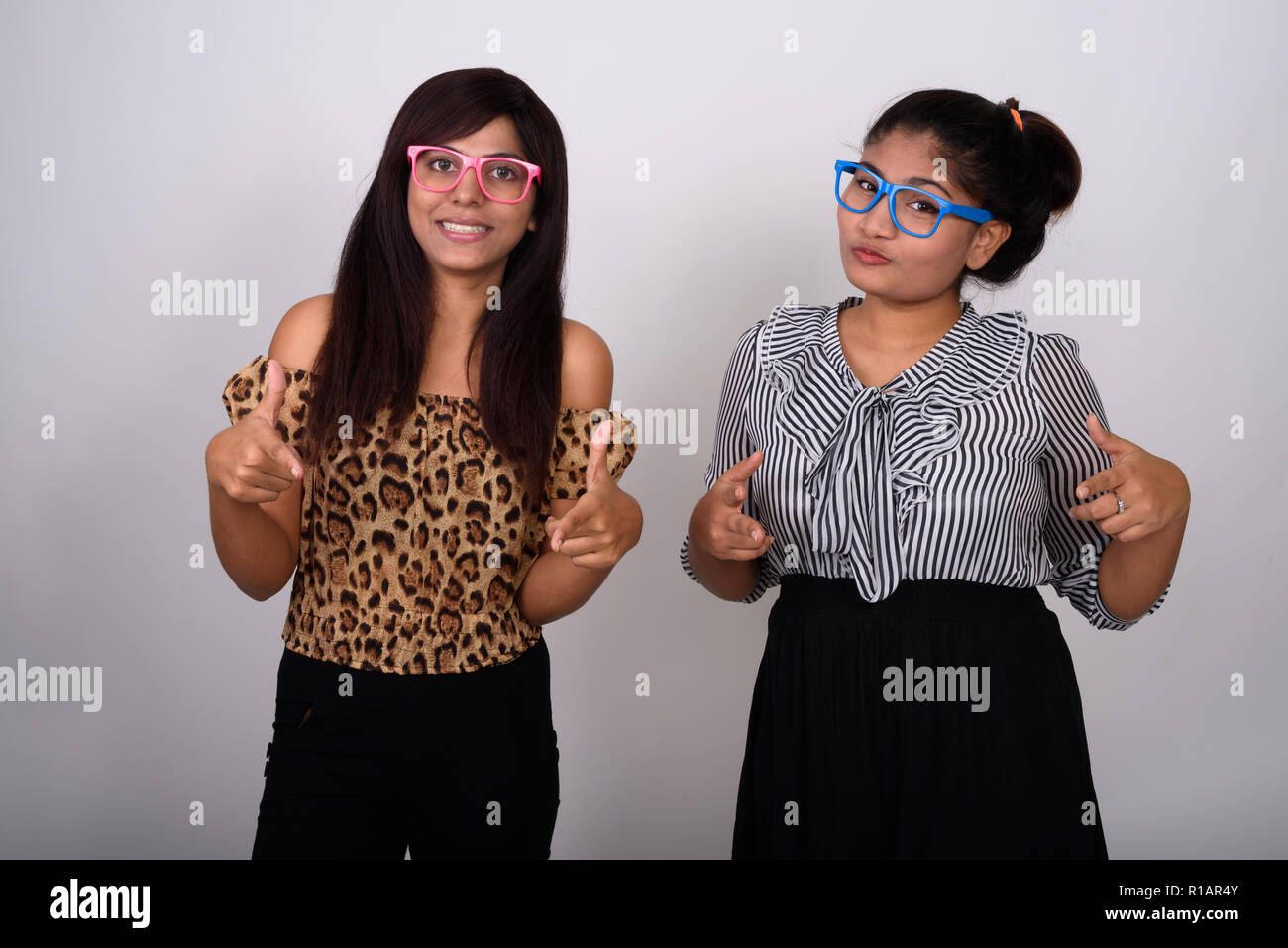 Studio shot di due giovani felici persiano amici donna sorridente whi Foto Stock