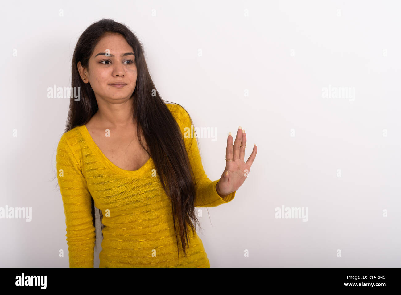 Studio shot della giovane donna indiana che mostra la mano di arresto segno per il Foto Stock