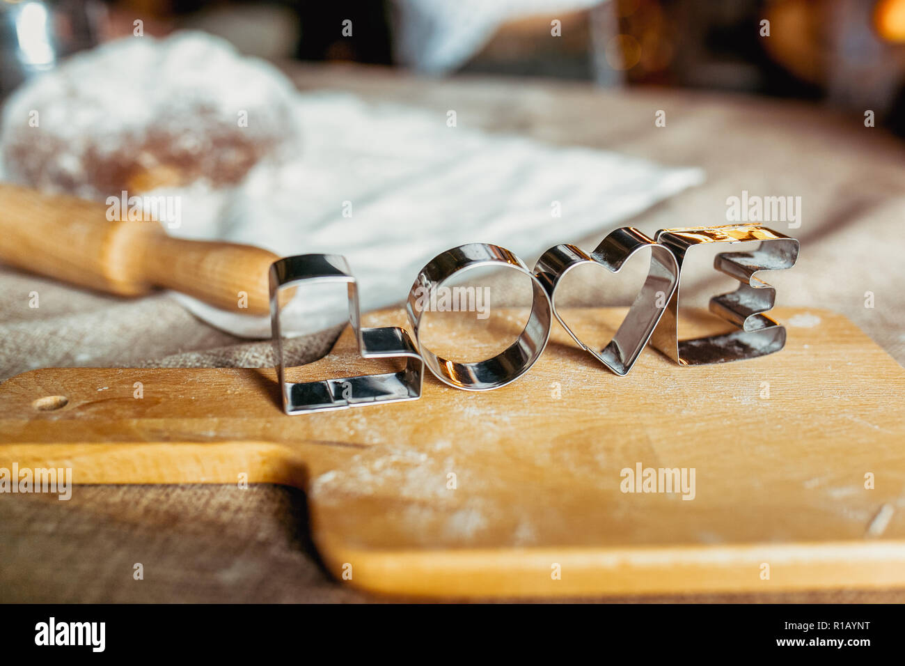 Teglie su una tavola di legno ricoperta di farina cotta al forno. Impasto arrotolato con un pattern e il cookie di varie forme. Tema d'amore. Biscotto backgrou cottura Foto Stock