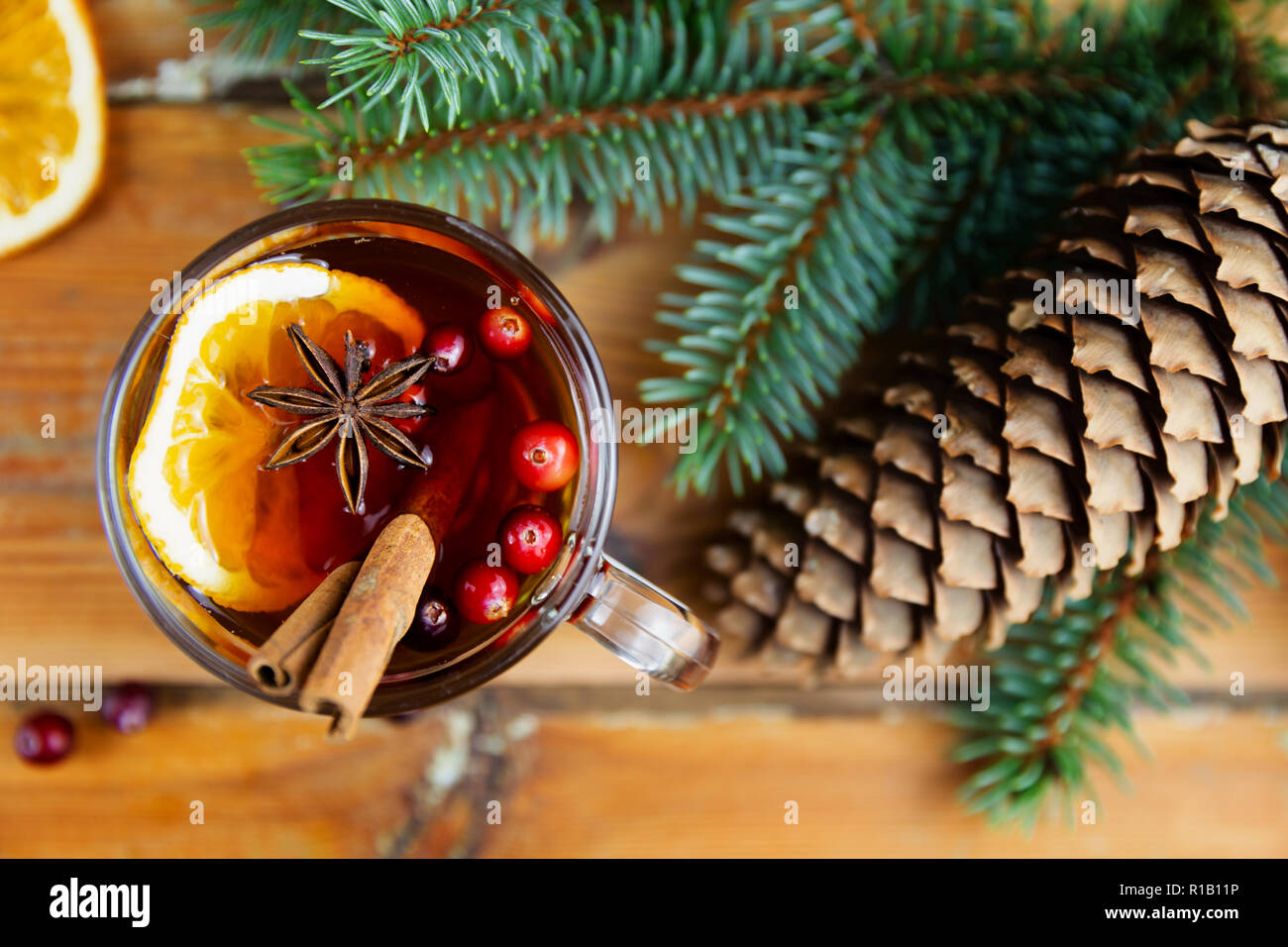 Natale vin brulé con cannella, spezie e fettine di arancia su uno sfondo di legno. Inverno bevanda calda Foto Stock