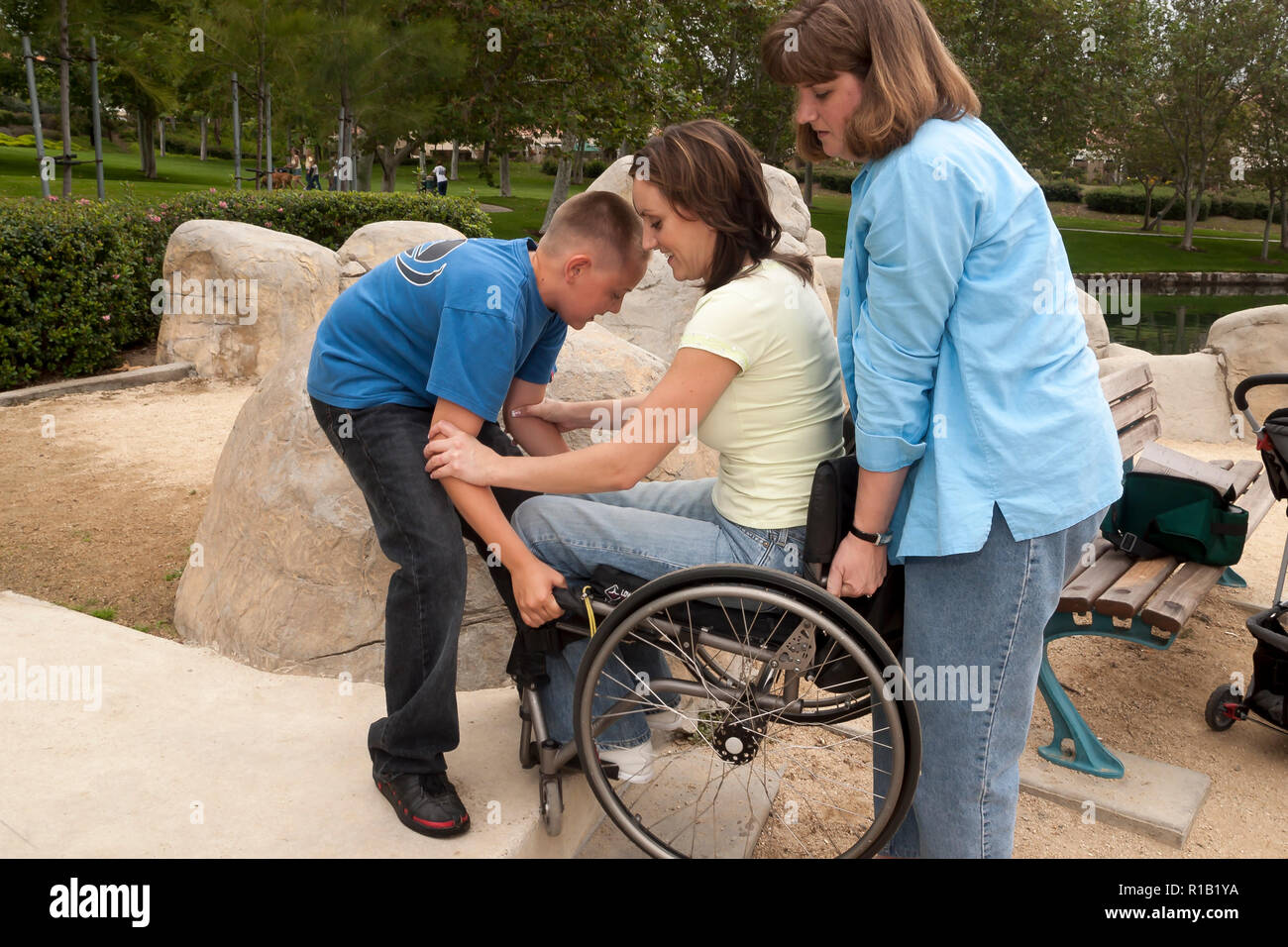 Ragazzo aiutare la sua zia di sollevare la sua madre fino a passo nel parco. Signor © Myrleen Pearson ...Ferguson Cate Foto Stock