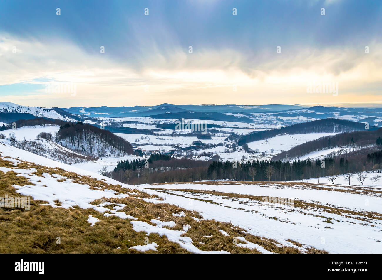 Paesaggio invernale sulla Wasserkuppe con la neve e il cielo drammatico in Rhoen montagne, Germania Foto Stock