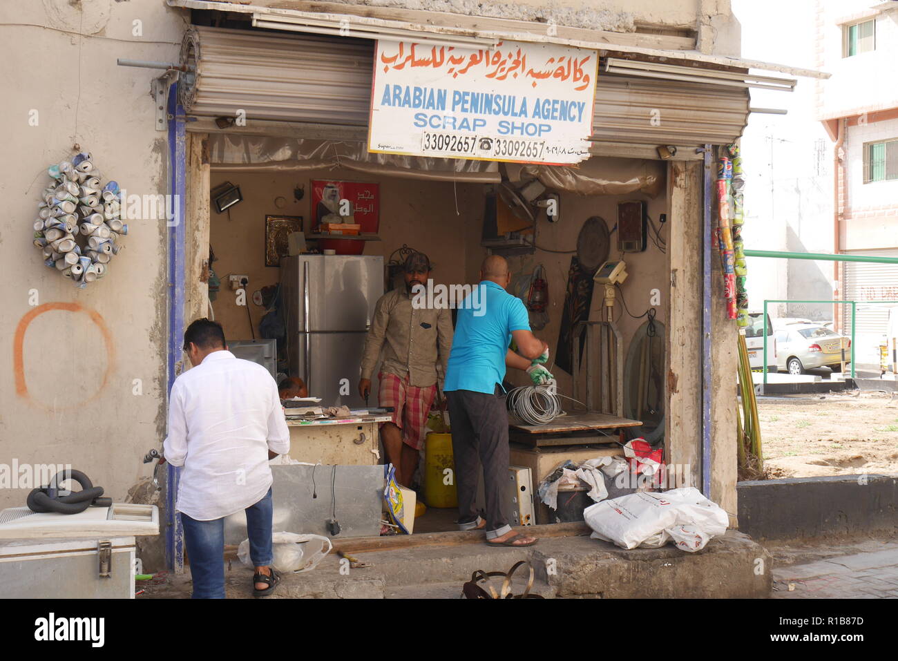 Lavoratori indiani in un metallo di scarto shop, Muharraq souk, Regno del Bahrein Foto Stock