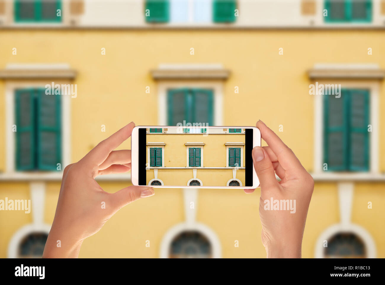 Un turista è di scattare una foto di un modello dal windows della facciata di uno degli edifici in Italia a Roma su un telefono cellulare Foto Stock
