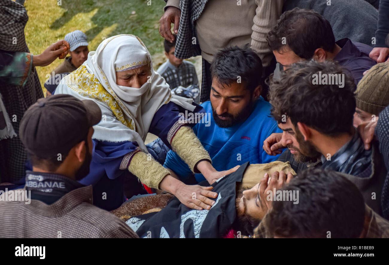 (Nota del redattore: immagine raffigura la morte.) Una relativa degli uccisi militante Liyakat Ahmed visto toccando il cadavere durante il suo corteo funebre al suo villaggio natale di Pulwama. Migliaia di persone hanno partecipato ai funerali preghiere dei due militanti che sono stati uccisi in uno scontro a fuoco con le forze di governo nel sud del Kashmir del distretto di Pulwama 40km dalla capitale estiva Srinagar. I militanti, secondo l Ispettore generale di polizia, Kashmir gamma, SP Pani, sono stati uccisi in un "molto breve" sparatoria nel villaggio Tikken. Foto Stock