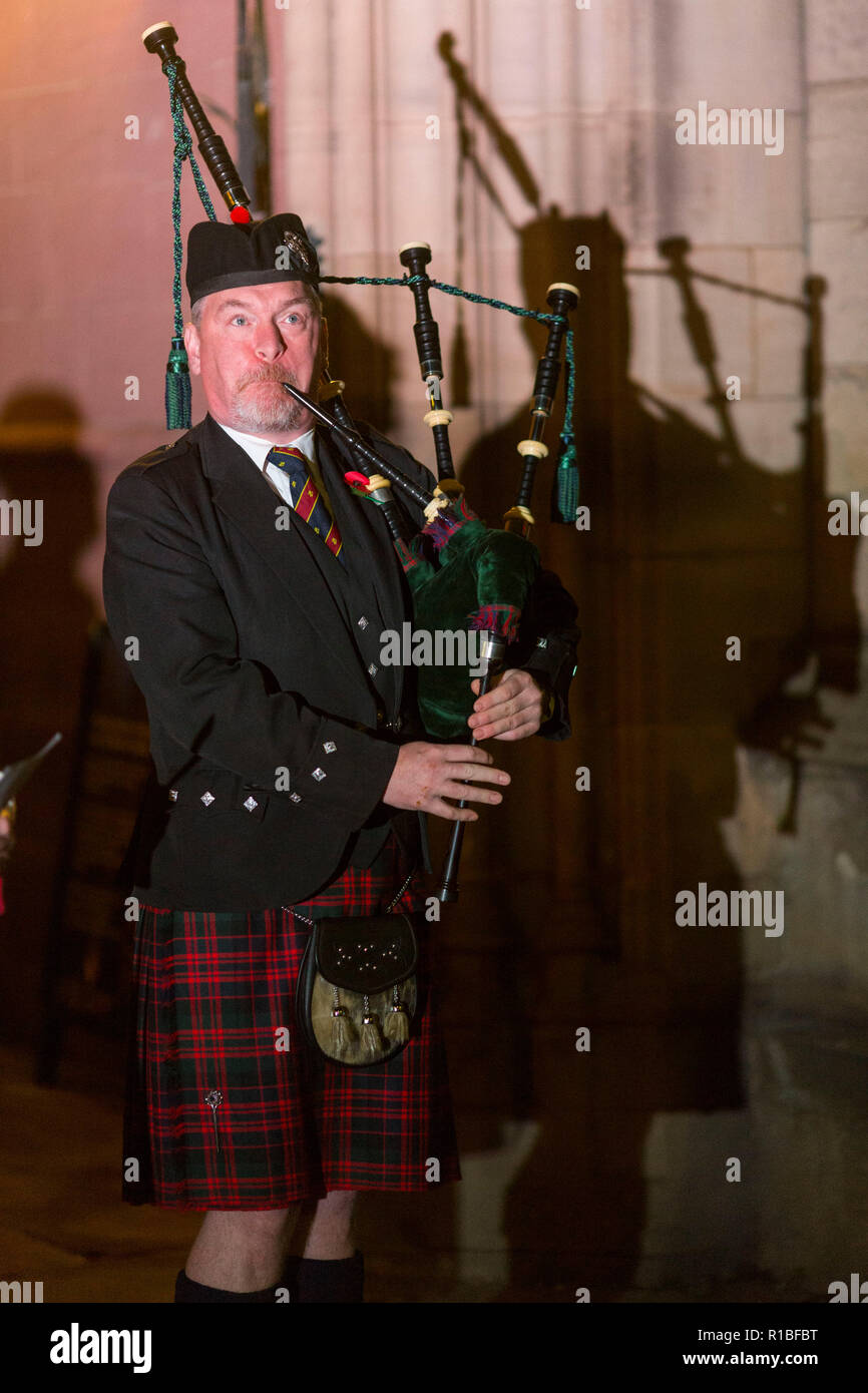 Manchester , in Inghilterra , 11 novembre 2018 il giorno dell'Armistizio in Manchester. Oggi (Domenica 11 Novembre) segna cento anni dopo la fine della Prima Guerra Mondiale. Alle 6 di mattina a lone piper riproduce la musica tradizionale scozzese lamento, Battaglia O'er, al di fuori della Cattedrale di Manchester per inaugurare delle commemorazioni. Piper Neil Macdonald ha aderito circa un migliaio di altri pipers in tutto il Regno Unito e in tutto il mondo a giocare alle ore 6 antimeridiane. Credito: Chris Bull/Alamy Live News. Foto Stock