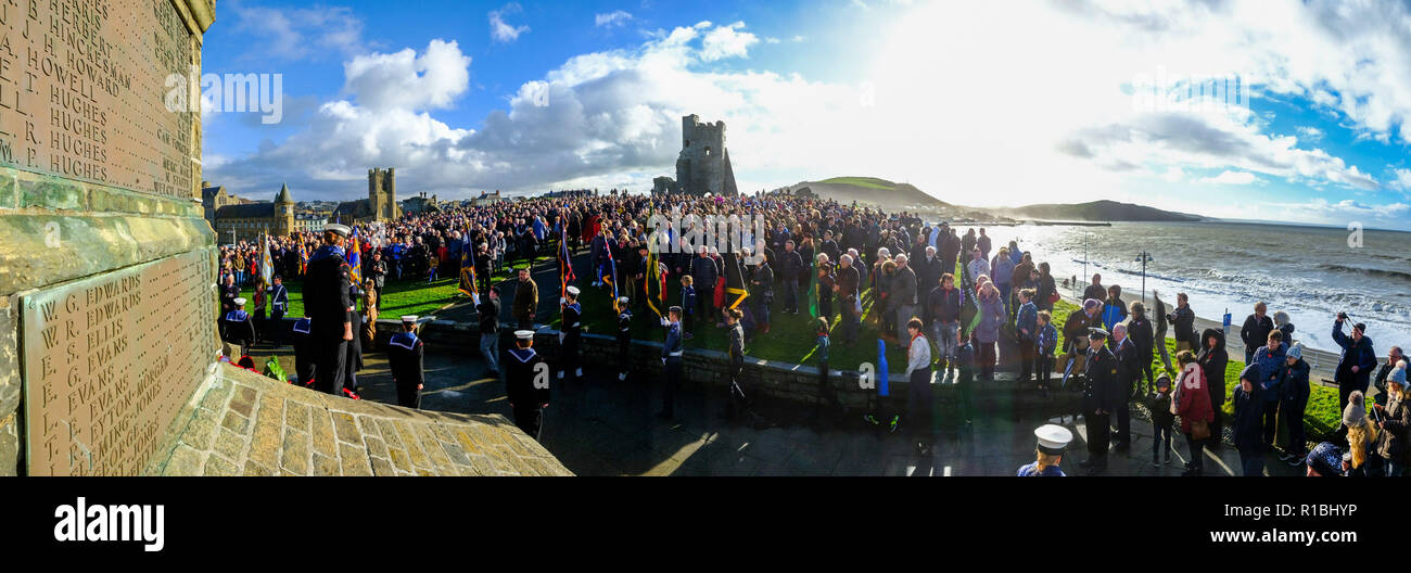 Aberystwyth Wales UK, 11/11/2018. gente radunarsi a gettare ghirlande e per ricordare i caduti di tutte le guerre e i conflitti, sul ricordo la domenica e il centesimo anniversario dell'armistizio che ha portato a termine la prima guerra mondiale, molto ventoso ma condizioni luminose all'iconico monumento ai caduti in guerra nel castello promontorio in Aberystwyth sulla costa esposta di Cardigan Bay, West Wales Photo credit Keith Morris / Alamy Live News Foto Stock