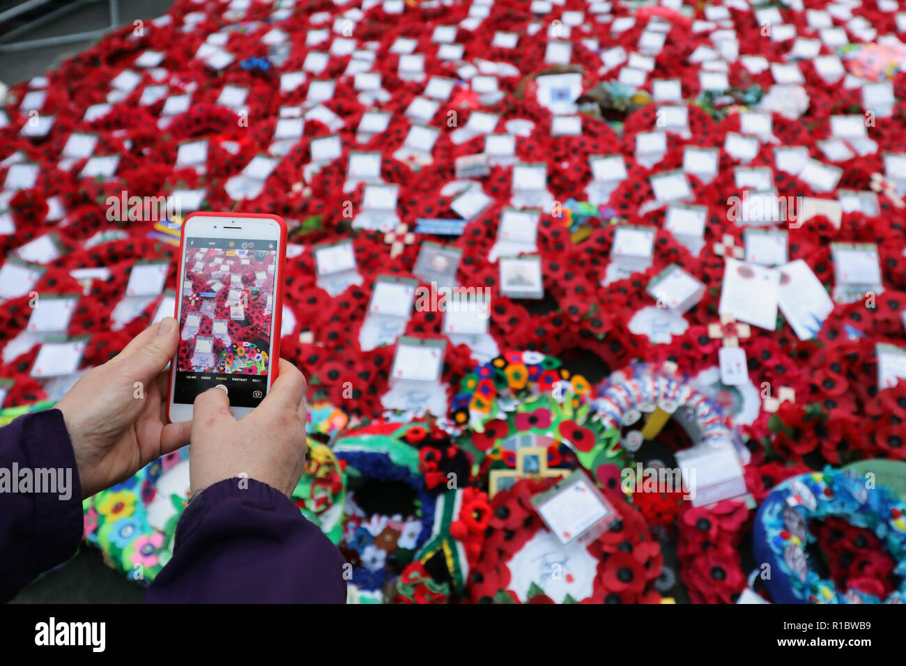 Londra, Regno Unito. 11 novembre 2018. Scattare una foto con un telefono cellulare del papavero rosso ghirlande e la folla presso il Cenotafio sul100th anniversario della Prima Guerra Mondiale armistizio, Whitehall, Londra, UK Credit: Paul Brown/Alamy Live News Foto Stock