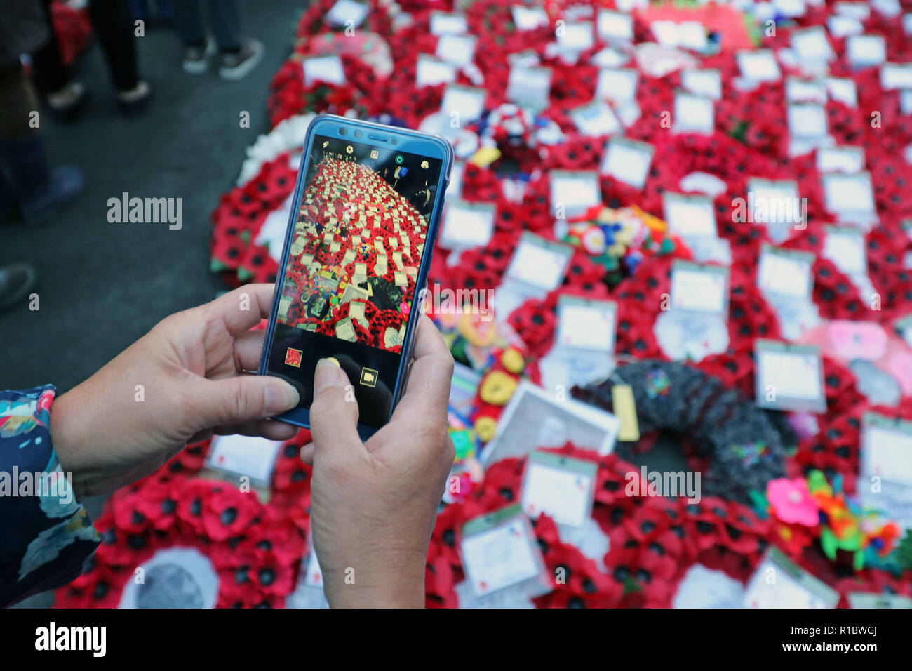 Londra, Regno Unito. 11 novembre 2018. Scattare una foto con un telefono cellulare del papavero rosso ghirlande e la folla presso il Cenotafio sul100th anniversario della Prima Guerra Mondiale armistizio, Whitehall, Londra, UK Credit: Paul Brown/Alamy Live News Foto Stock
